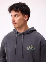 Canguro con capucha y cordones ajustables, de color gris claro. Presenta un logo bordado en el pecho y un parche decorativo en el puño de la manga derecha. Cuenta con un bolsillo frontal tipo canguro y puños acanalados.