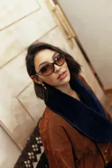 Chaqueta confeccionada en gamuza color negro con amplio cuello smoking de corderito en tono crudo. Presenta un diseño corto, cruzado con doble abotonadura y botones metálicos, mangas amplias y bolsillos.