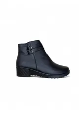 Bota corta de cuero sintético color negro, con taco bajo cuadrado, suela dentada y dos tiras decorativas con hebillas metálicas en el lateral.