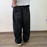 Pantalón jean de corte barrel, color azul clásico con efecto desgastado y diseño amplio y curvado en las piernas.