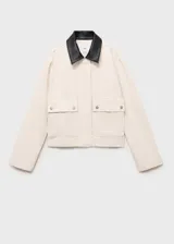 Chaqueta recta de algodón estilo vaquero, color blanco, con manga larga, cuello camisero de efecto piel en contraste, cierre oculto de cremallera y botones, y dos bolsillos delanteros de parche con solapa.