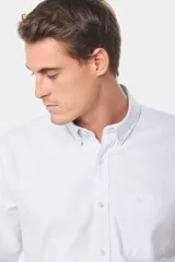 Camisa celeste a rayas verticales, de corte clásico, con cuello abotonado, manga larga y bolsillo en el pecho con logo bordado.