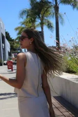 Musculosa sin mangas color beige claro, con escote cuadrado y diseño ajustado con costuras visibles en el frente.