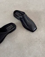 Zueco de cuero vacuno color tostado, con diseño de punta cuadrada y estilo destalonado.