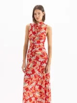Vestido midi sin mangas con estampado floral en tonos rojos y celestes, cuello alto y detalle fruncido en el centro delantero.