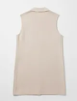 Chaleco largo tejido color blanco de la marca Sioni, con cuello solapa, doble botonadura dorada en el frente y bolsillos aplicados.