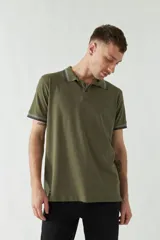 Remera polo negra de manga corta con ajuste regular. Presenta cuello y puños con ribete a rayas en gris y bordó. El logo de la marca está estampado en el pecho.