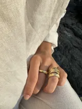Anillo de diseño enlazado con textura irregular, realizado a mano en bronce. Presenta un diseño abierto que permite regular su tamaño con suavidad.