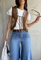 Chaleco marrón de gamuza con bordados florales en color crema, con cierre frontal con lazos.