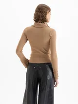 Sweater de tejido de punto fino color marrón, con ajuste al cuerpo, cuello alto con detalle de volados y moño, y mangas largas con puños acampanados con volados.