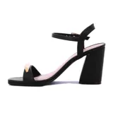 Sandalias negras de tacón ancho con tira delantera decorada con una aplicación metálica dorada, tira en el talón y tira ajustable al tobillo con hebilla.