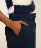 Pantalón de vestir azul marino, de corte recto, con pinzas delanteras, bolsillos laterales y traseros. Se ajusta a la cintura con cierre invisible y trabillas para cinturón.