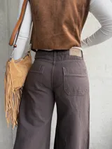 Jean de corte wide leg en color chocolate, confeccionado en denim con costuras verticales decorativas y ruedo deshilachado.