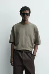 Camiseta boxy fit color verde militar con efecto lavado, confeccionada en tejido compacto de algodón con cuello redondo y manga corta.