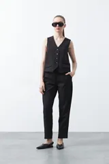 Chaleco sastrero color marrón oscuro, con escote en V, cierre frontal de botones y pinzas de entalle.