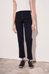 Pantalón de jean negro, de corte recto y tiro medio, con cierre frontal de botones.