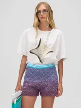 Short de punto tejido con patrón de rombos en tonos degradados de celeste y amarillo. Presenta una pretina elástica y un calce suelto.