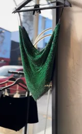 Top halter confeccionado en malla metálica con pedrería verde brillante, con escote pronunciado y diseño triangular en el frente.
