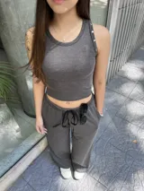 Pantalón negro de tela morley elastizada con líneas finas, corte recto y holgado, cintura elástica con cordón ajustable y bolsillos laterales.