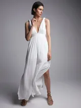 Mono largo blanco con escote en V, breteles finos con lazo y tajo lateral en la pierna.