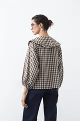 Camisa de algodón con estampado de cuadros vichy, cuello grande con volados y mangas largas con puños elásticos.