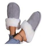 Pantufla cerrada de gamuza gris con interior y borde de peluche blanco, suela de goma antideslizante.