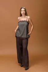 Musculosa de breteles finos con diseño a cuadros oscuros, decorada con delicados detalles de puntilla negra en el escote, laterales y ruedo. Presenta un corte holgado y fluido.