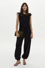 Blusa vaporosa negra de viscosa sin mangas, con volados de algodón en los hombros.