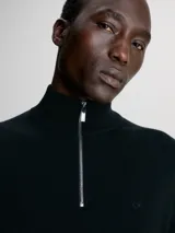 Sweater negro de lana merino con cuello alto y cremallera corta.