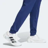 Pantalón de entrenamiento Adidas Essentials Feelready, color azul, con ajuste clásico, bolsillos con cierre, cordón de ajuste en la cintura y el logo de la marca en blanco en la pierna izquierda. Incorpora tecnología Climacool para regular la temperatura y expulsar la humedad.