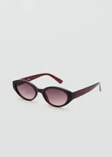 Lentes de sol con montura ovalada de pasta color bordó y cristales degradados.