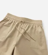 Short color beige de sarga de algodón, con cintura elástica, lazo ajustable y bolsillos laterales. Corte holgado.