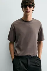 Camiseta de corte relajado con cuello redondo y manga corta, confeccionada en tejido de algodón liso.