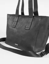 Cartera tipo shopper de cuero vegano en color marrón con acabado efecto gastado. Presenta un diseño amplio y flexible, ideal para uso diario.