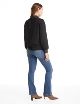 Buzo de modal color negro con cuello solapa y escote en V con botones a presión. Presenta mangas largas con puños elastizados y detalles de textura en el cuello y puños.