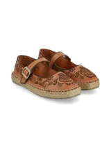 Ballerina tipo alpargata de cuero napa color tostado, con base de yute trenzado y suela levemente elevada. Presenta bordados marrones con motivos florales y espirales, tira de ajuste en el empeine con hebilla metálica y ribete oscuro.