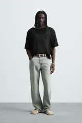 Camiseta de punto negro, corte relajado, con cuello redondo amplio y manga corta. El tejido es ligero y calado.