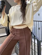 Pantalón de calce cómodo color marrón, con cintura elástica en contraste color crema, bolsillos laterales funcionales y diseño con recortes y costuras overlock a la vista.