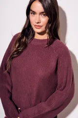 Sweater de algodón color azul, de punto grueso, con cuello redondo y mangas largas.