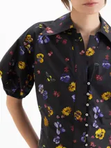 Camisa de poplín negro con estampado floral multicolor, de calce entallado, cuello clásico y mangas cortas abullonadas con puños elásticos.