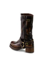 Botas de cuero marrón con detalles de hebillas y tachas.