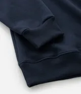 Buzo de manga larga color azul marino, confeccionado en tejido de algodón con felpa, con cuello polo blanco contrastante y abertura frontal con botones.