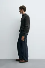 Sweater de punto en canalé color negro, de corte regular fit, cuello redondo y manga larga con terminaciones en rib.