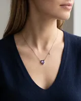 Collar de plata con cadena fina y dije en forma de corazón de cristal violeta tornasolado, acompañado de un pequeño detalle de cristal brillante en la cadena.