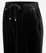 Pantalón de corte recto confeccionado en terciopelo, con cintura elástica ajustable mediante lazo y bolsillos laterales.