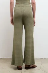 Pantalón largo color crema, de punto acanalado y corte recto.