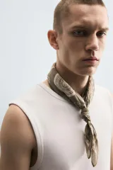 Musculosa blanca de algodón con cuello redondo y sisas amplias.