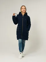 Campera puffer larga de Tommy Hilfiger en color azul marino. Presenta un diseño acolchado horizontal, cierre frontal completo con cremallera, capucha ajustable con cordones y dos bolsillos laterales con cierre. Incluye detalles distintivos de la marca.