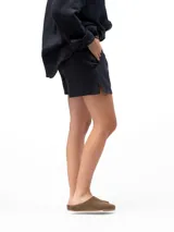 Short de lino color negro, con cintura elástica y bolsillos laterales, de diseño holgado y cómodo.