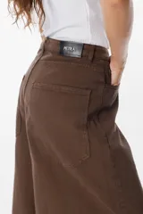 Jean de corte wide leg en color bordó, confeccionado en denim de algodón. Presenta tiro medio, bolsillos traseros amplios y una silueta holgada y fluida.